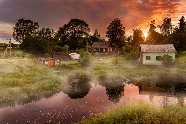 Morgen im Dorf im Sommer am See