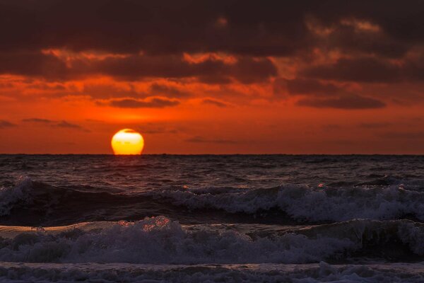 Coucher de soleil rouge sur la surface de la mer