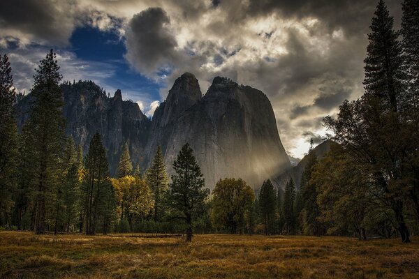 Mountains in the forest against the background of the coffin sky