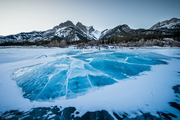 Gefrorener See im Winter vor dem Hintergrund der schneebedeckten Berge