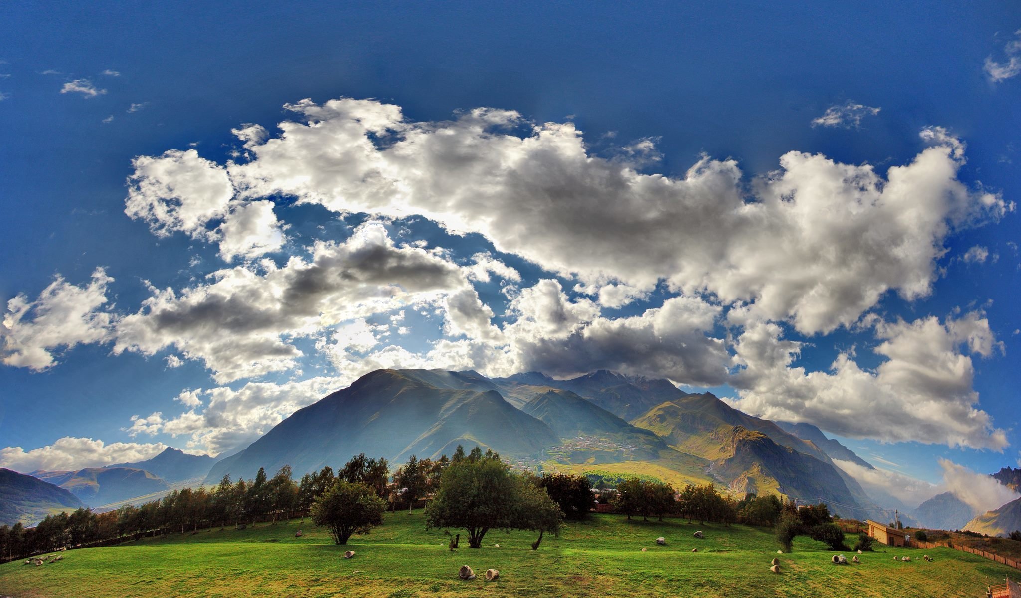 georgien wolken himmel feld gras berge kasbegi dorf