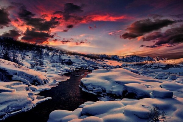 Alba invernale in gorahi fiume che si fa strada attraverso la neve