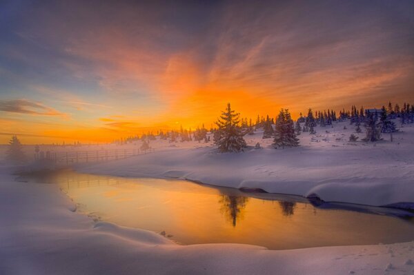 Alba arancione sul fiume invernale