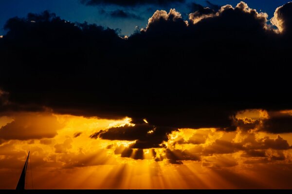 Les rayons du soleil se brisent derrière les nuages