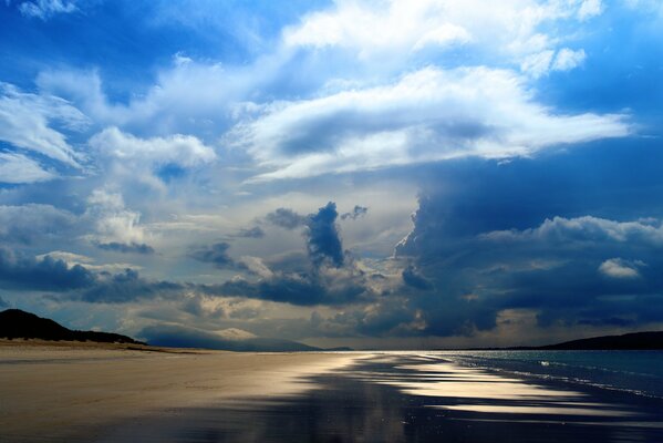 Costa del mar bajo las nubes azules