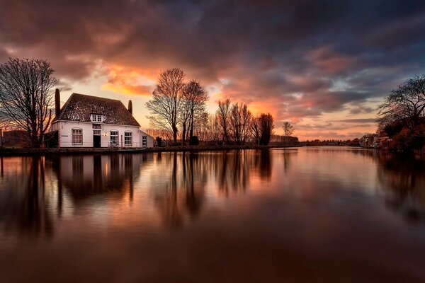 Maison au bord de la rivière se reflète dans l eau