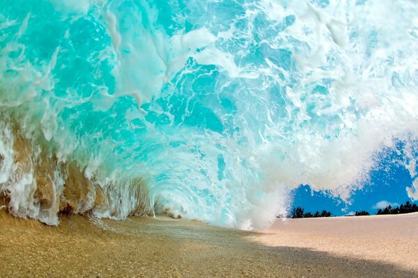Eine Welle, die den Sand am Strand gefangen hat