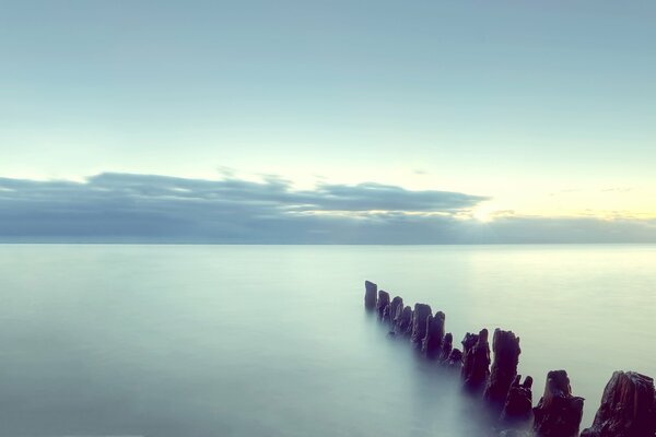 Sonnenuntergang am Meer und Säulen im Wasser