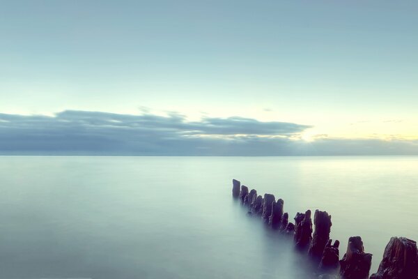 Coucher de soleil au bord de la mer et des piliers dans l eau