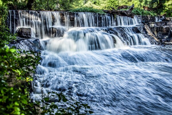 High-quality photo of a waterfall against a green landscape