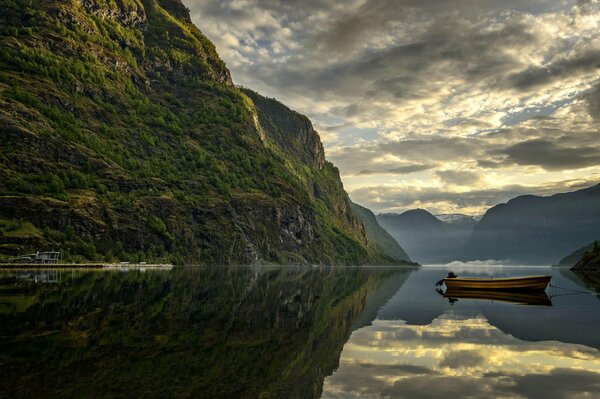 The boat is reflected in the mirror surface of the water