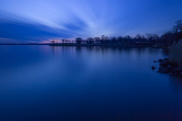 Un grande lago al crepuscolo blu