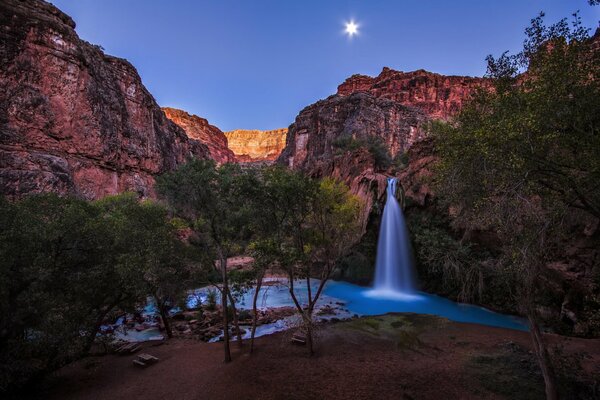 Waterfall in the mountains and a star in the sky
