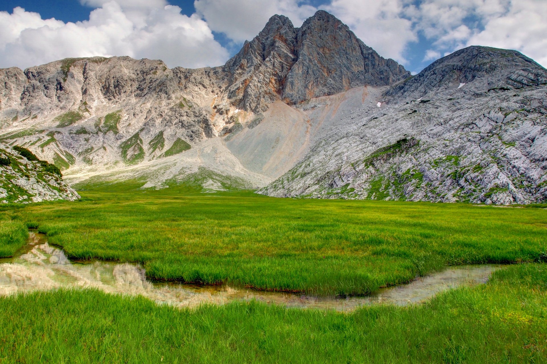 mountain ground mountain grass nature reed creek sky clouds photo