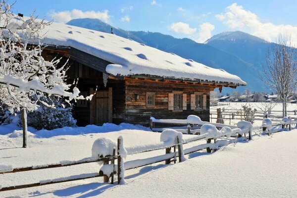 Un día soleado de invierno y una cabaña en las montañas