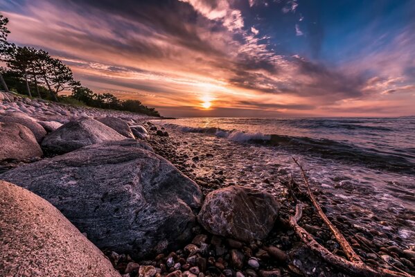 La beauté du Danemark, hornbaek, le surf calme apporte doucement des pierres pointues sur le rivage