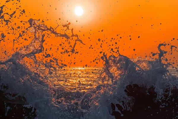 Éclaboussures de mer sur fond de coucher de soleil lumineux