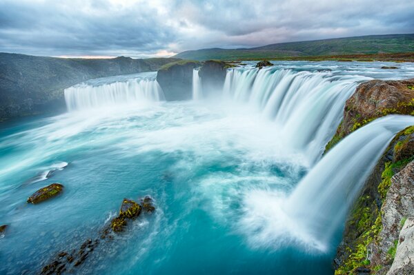 Wolken über dem Wasserfall mit Steinen