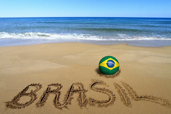 Мяч с изображением флага Бразилии на берегу моря