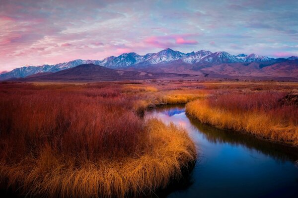 A small river against the background of mountains in the evening