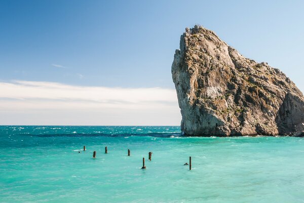 Ein Felsen, der aus dem blauen Meer steigt