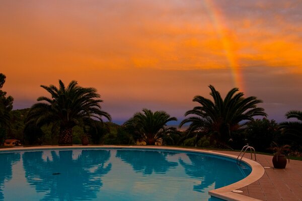 Noche de arco iris cerca de la piscina