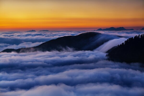 Aube dans les montagnes au-dessus des nuages