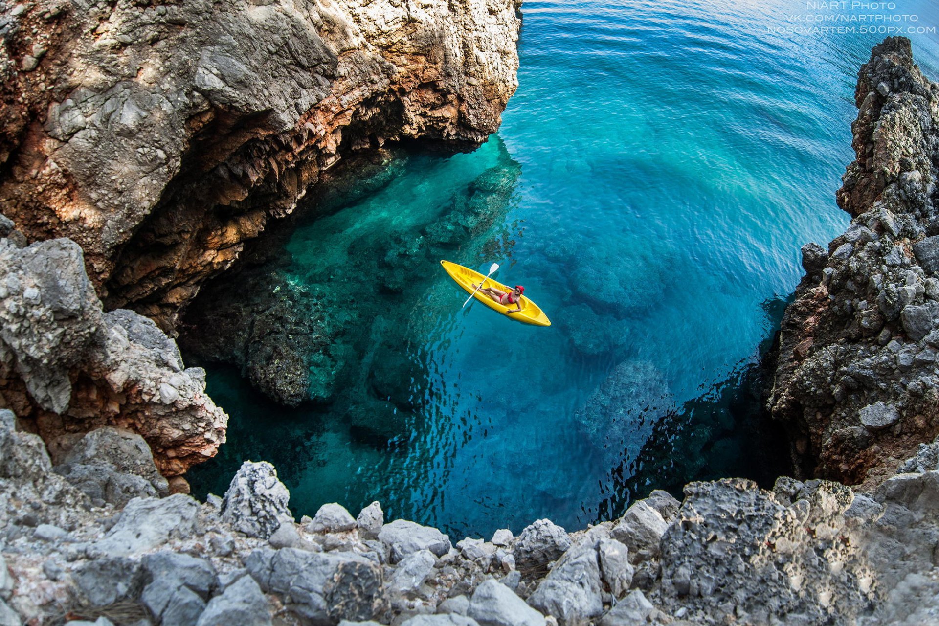 paesaggio oceano pietre rocce ragazza canoa