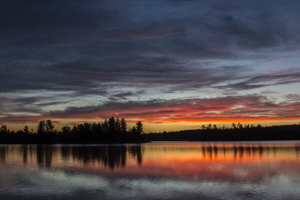 Natur Sonnenuntergang am See und Wald am Horizont