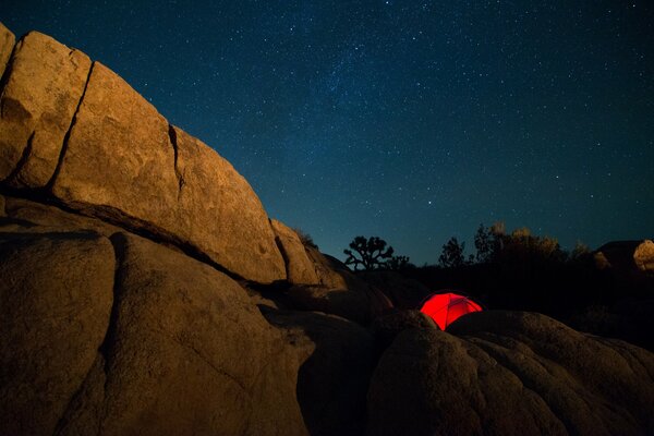 Czerwony namiot wśród gór nocą
