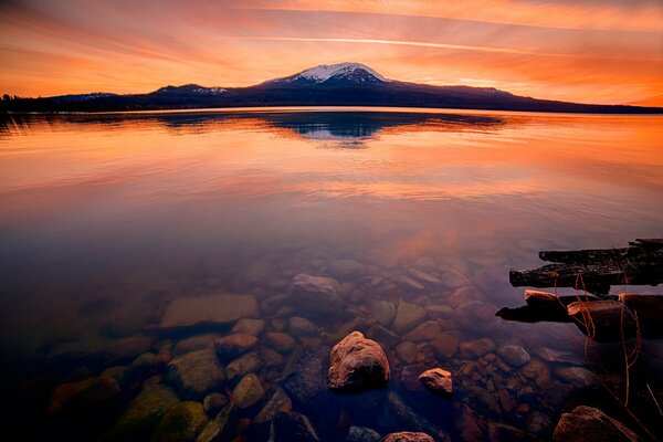 Puesta de sol sobre un lago de montaña transparente