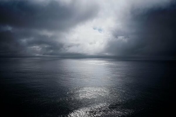 Calm sea in the moonlight through the clouds