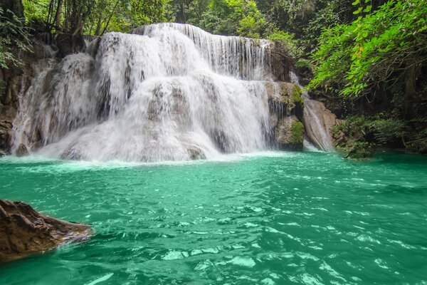 Azure river with a waterfall in the forest