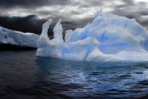 Panorama of an iceberg in the waves of the sea