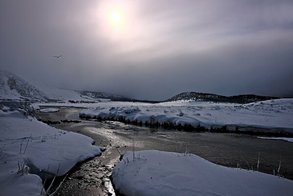 Rivière d hiver avec de la neige sur le rivage