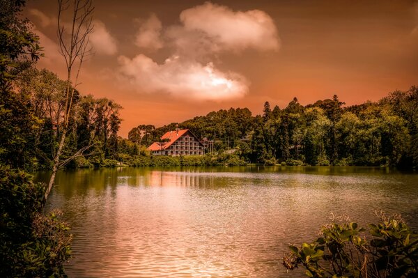 Casa con techo rojo en la orilla del lago