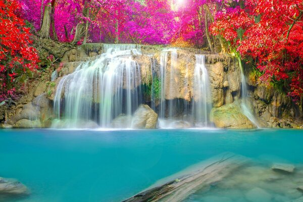 Wasserfall unter Steinen und Herbstbäume