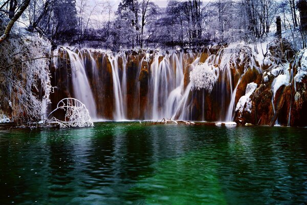 Paesaggio invernale Croato-la cascata cade nel fiume