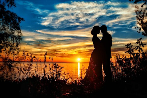 A couple in love by the sea at sunset