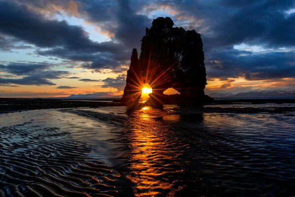 Roca, mar en el fondo de la puesta de sol