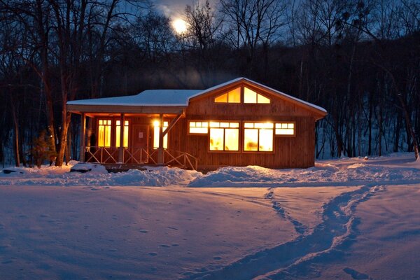 Casa cálida en el bosque de invierno. Una noche tranquila en el bosque