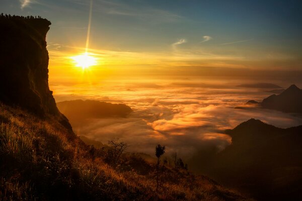 W Laosie widok słońca wśród chmur i skał