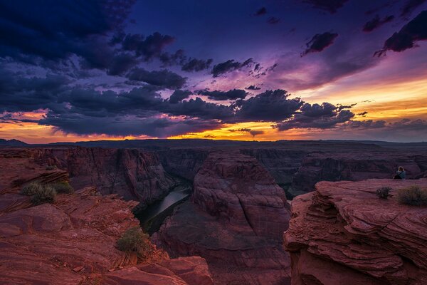 The rocks of the Grand Canyon under the clouds at sunset. Horseshoe Bend of the Colorado River. Arizona, USA