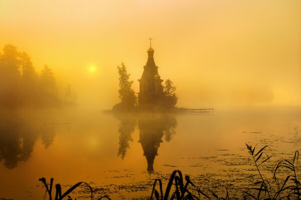 The church shrouded in fog over the water