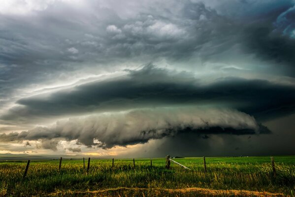 Terrible clouds over a green field