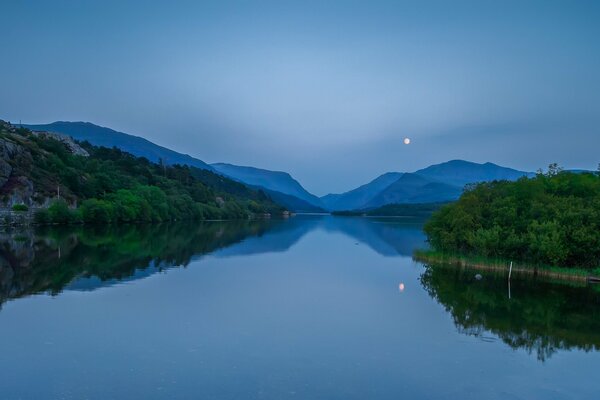 Cicha noc z pełnią księżyca nad jeziorem w Walii