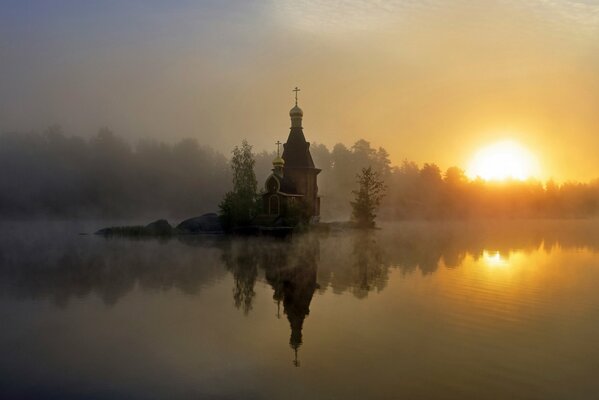 Reflet de l église au coucher du soleil dans le brouillard
