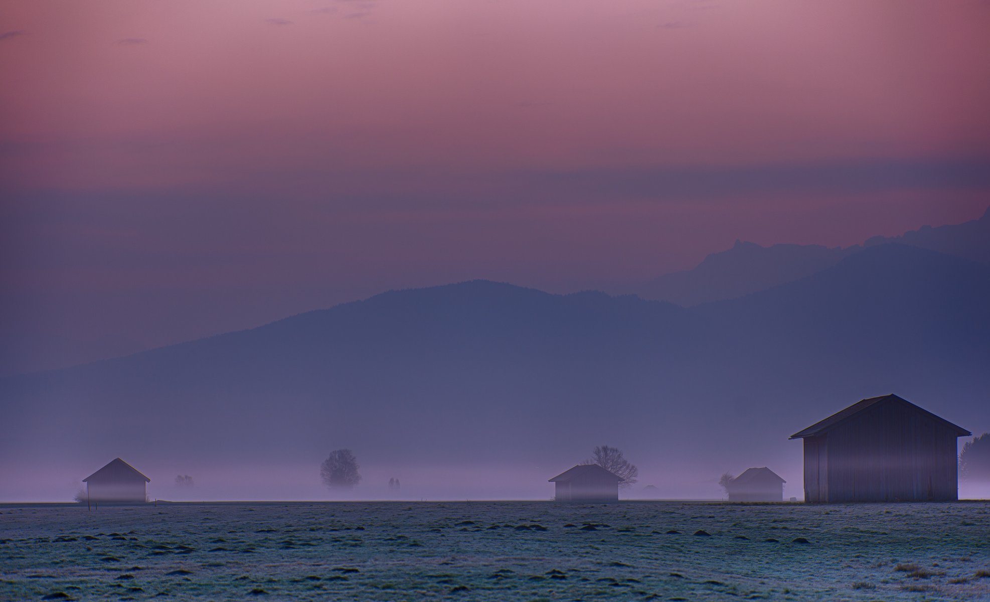 germania baviera karwendel alpi montagne radura colline alberi case foschia nebbia cremisi cielo prima dell alba mattina