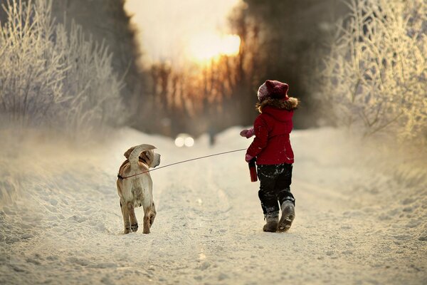 Winterspaziergang des Kindes mit Hund