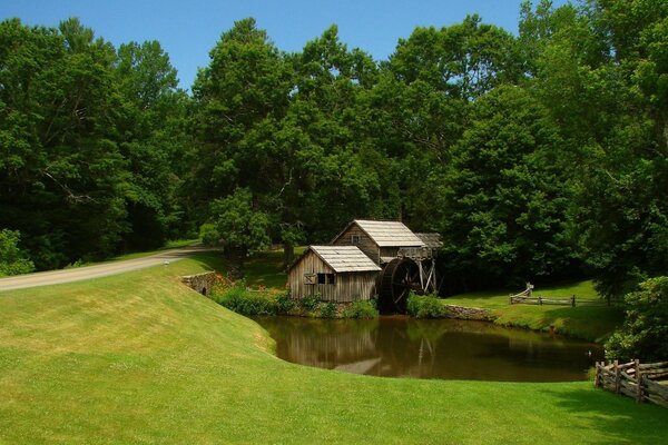 Holzhütte mit Mühle am Teich